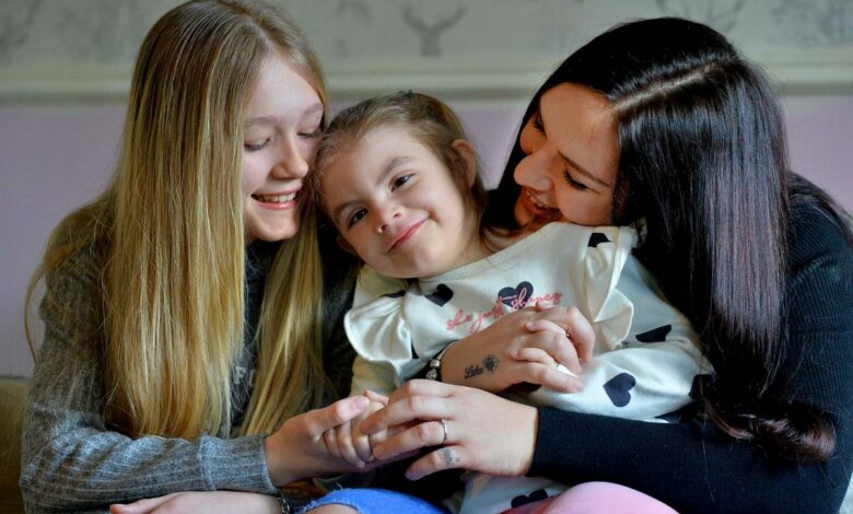 Irmã, Lola e sua mãe Carly, as tres são brancas e estão abraçadas em torno da Lola que está no meio