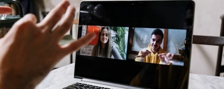 Imagem de um computador com imagem de duas pessoas falando em libras com o aluno se comunicando com elas
