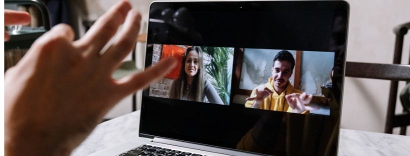 Imagem de um computador com imagem de duas pessoas falando em libras com o aluno se comunicando com elas