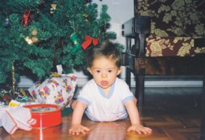 Samuel quando era bebê, ao lado de uma árvore de Natal.